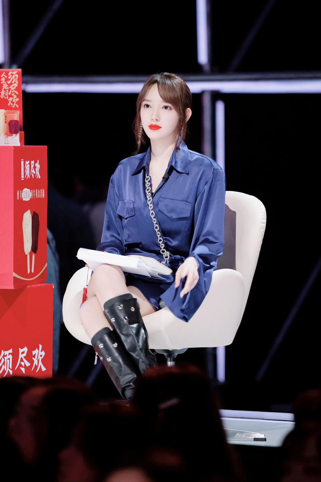 程潇身着宝蓝色缎面长款衬衫裙,鞋子搭配黑色厚底高筒马丁靴[5]