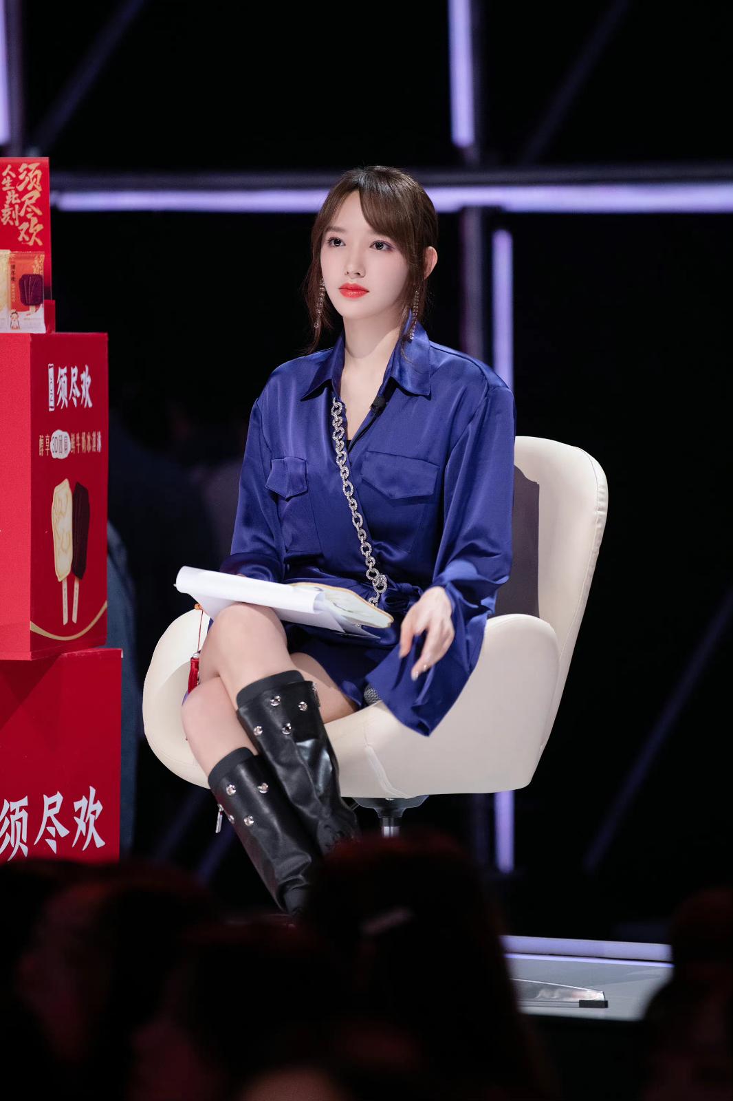 程潇身着宝蓝色缎面长款衬衫裙,鞋子搭配黑色厚底高筒马丁靴[8]